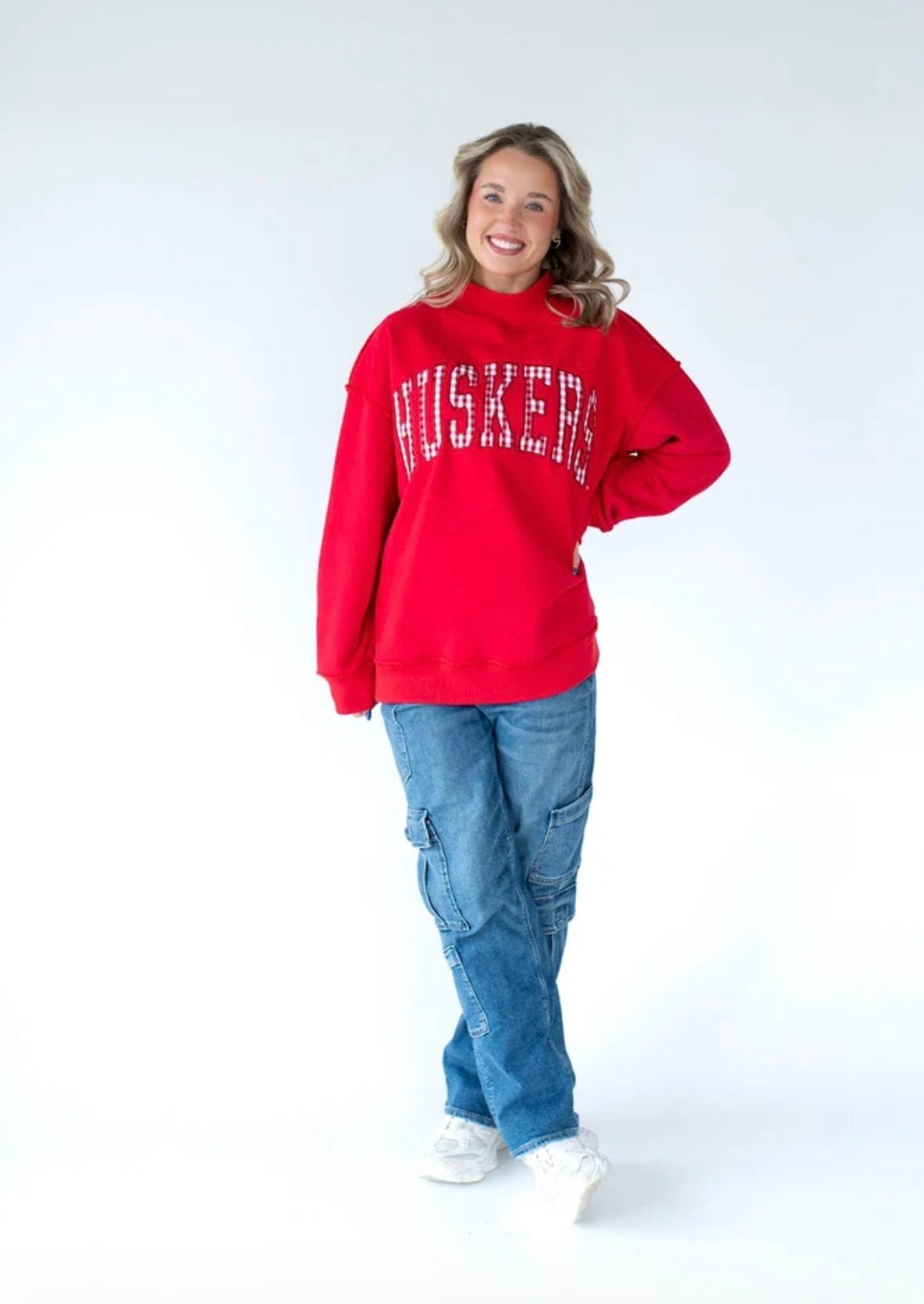 Nebraska Huskers red mockneck sweatshirt featuring white and red gingham HUSKERS lettering in a vintage collegiate style.