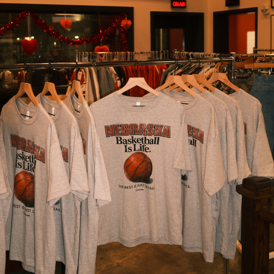 Nebraska Basketball Is Life graphic t-shirts hanging on a clothing rack