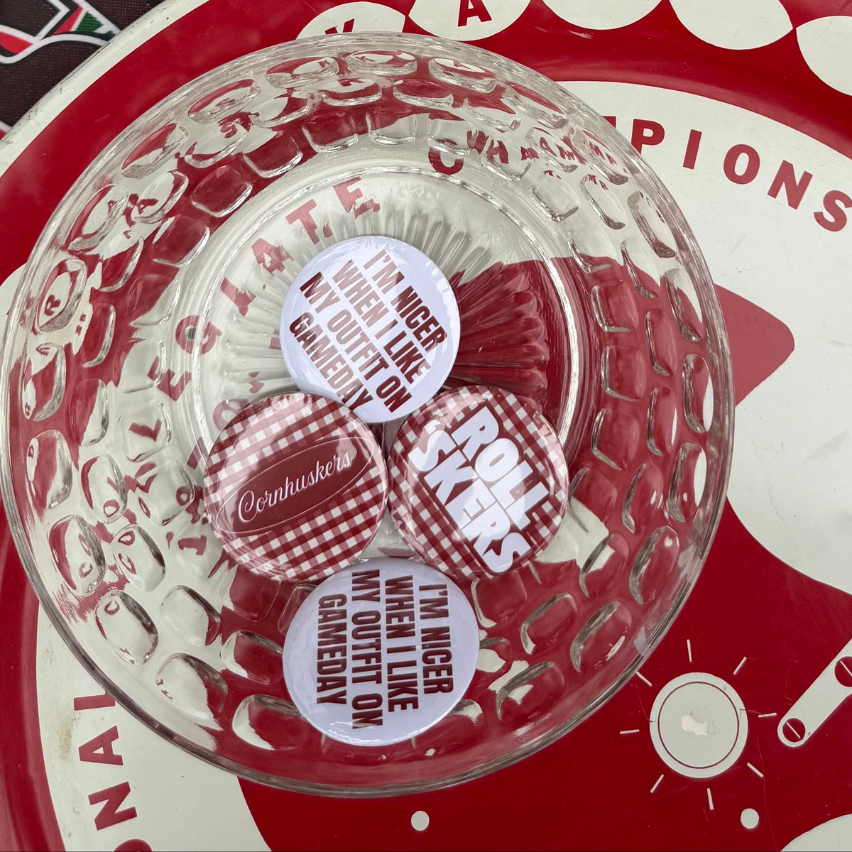 Bowl filled with assorted Nebraska-inspired pinback buttons from Vintage Cowboy