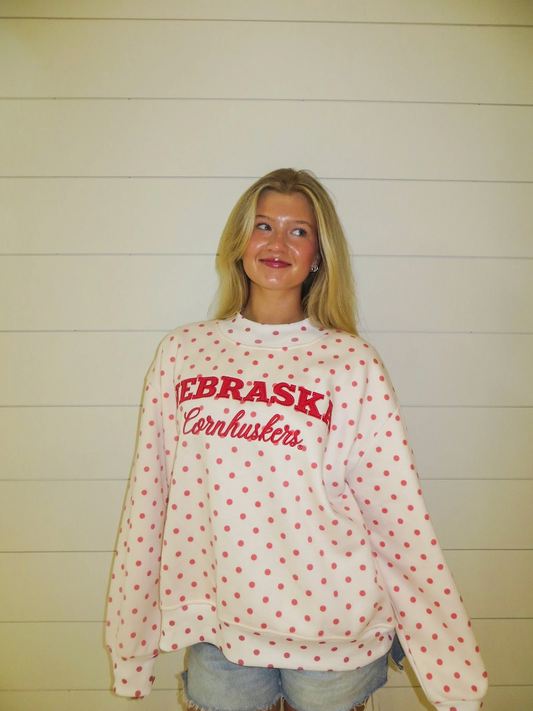 Model wearing a white and red polka dot Nebraska Cornhuskers mockneck sweatshirt