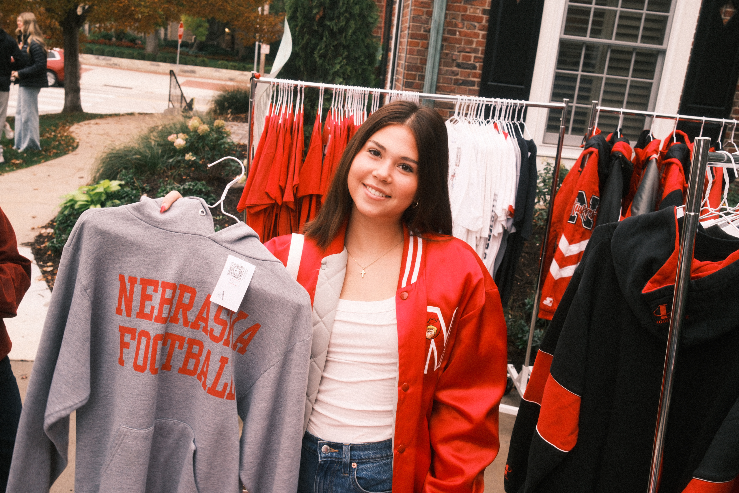 Shopper holding a vintage Nebraska Football sweatshirt at a Vintage Cowboy pop-up in Lincoln